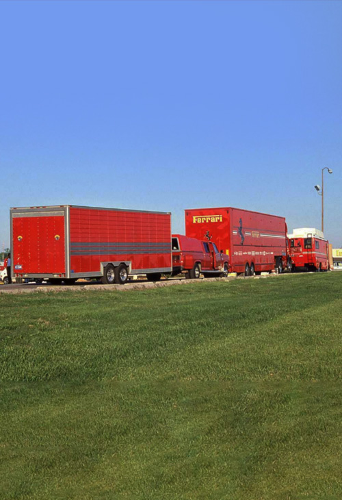 Camion e strutture del team Ferrari nel paddock di un circuito americano