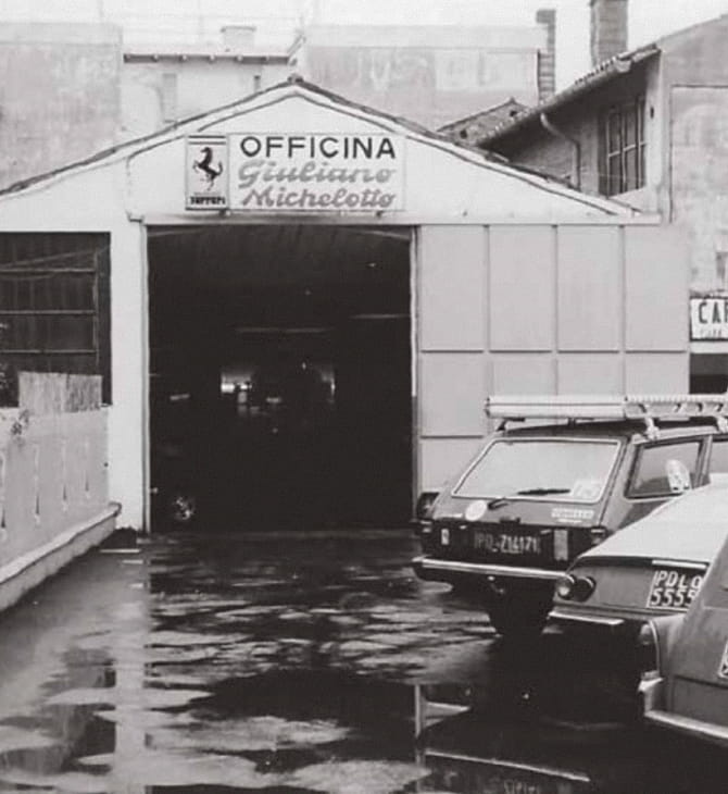 Esterno dell'Officina Giuliano Michelotto a Padova con insegna e logo Ferrari, foto in bianco e nero